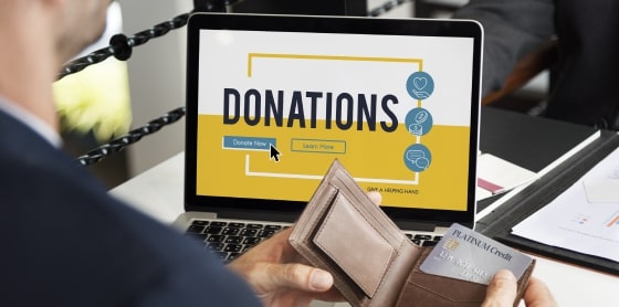 A person uses a wallet and credit card at a laptop with payment gateway page.
