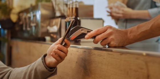 Customer uses smartphone for contactless payment via POS system and payment gateway.