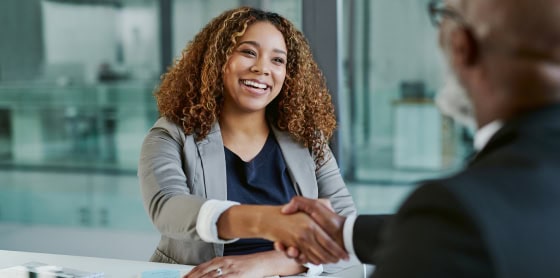 In a modern office, partners shake hands over a POS system and payment solution.