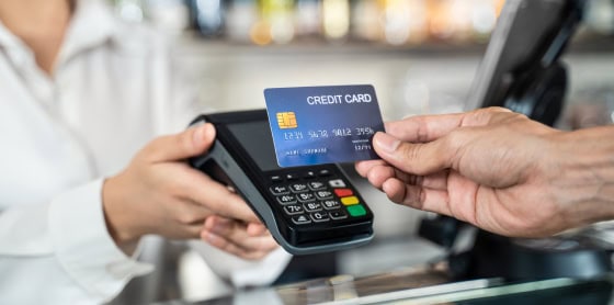 Merchant engaging POS system with credit card, showcasing payment gateway solutions.